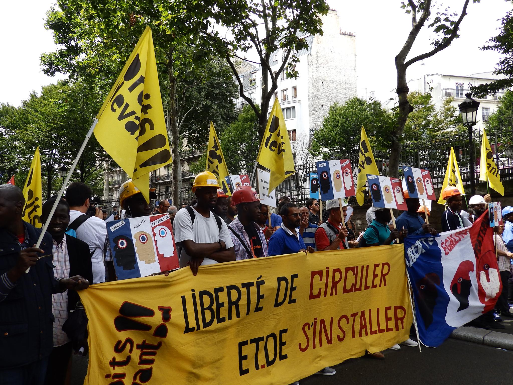 &#13;
Protesters from the Droits Devant migrants' rights group at a Bastille Day march &#13;