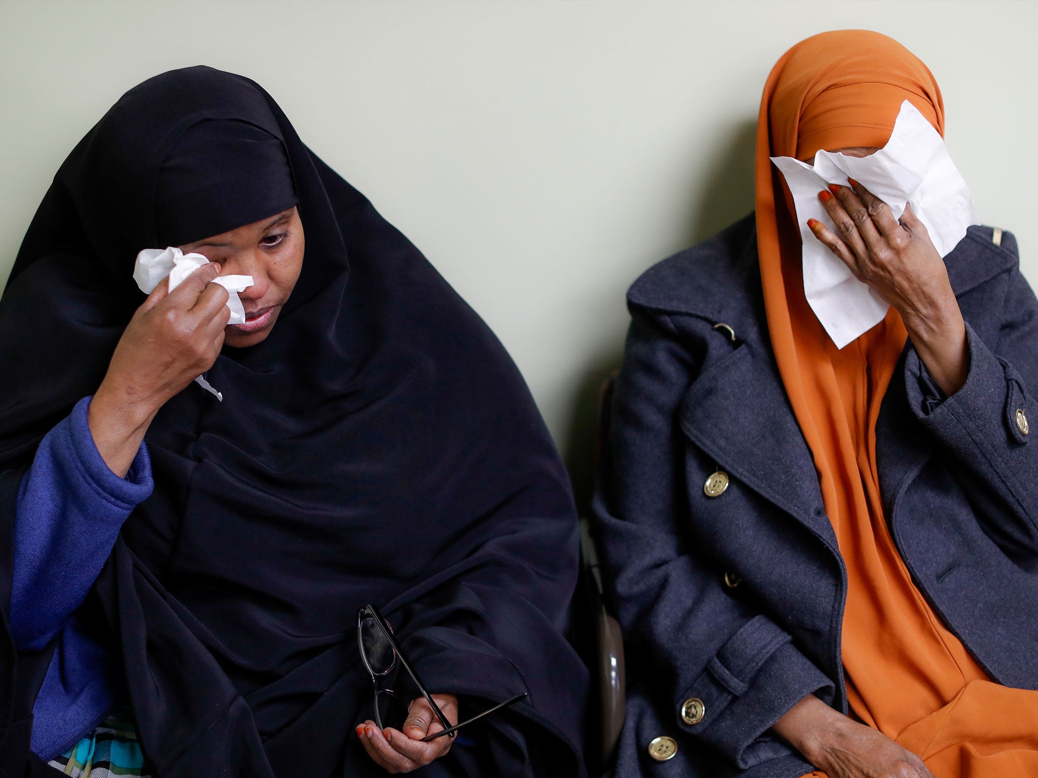 Somali refugees wipe away tears during an interview at the Community Refugee & Immigration Services offices in Ohio