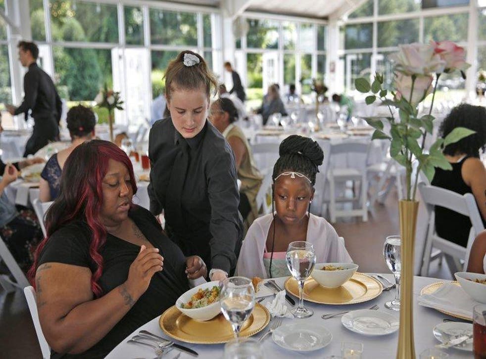 Waitress Katelin Decraene gives Trishell Crawford and her daughter Jacqueline Crawford salads at the reception