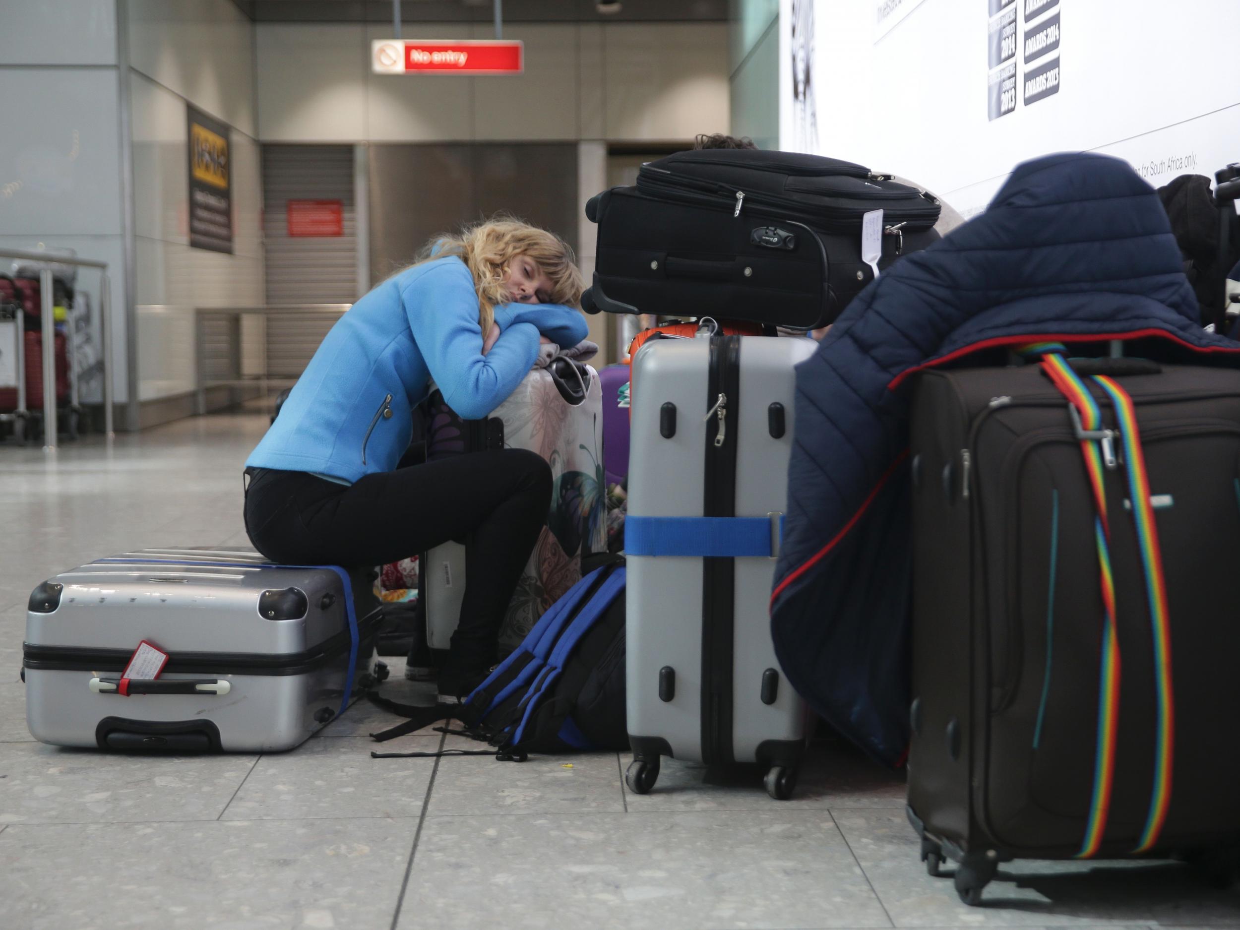 A traveller sleeps next to luggage at Heathrow Airport Terminal 5 after British Airways flights where cancelled after an IT systems failure