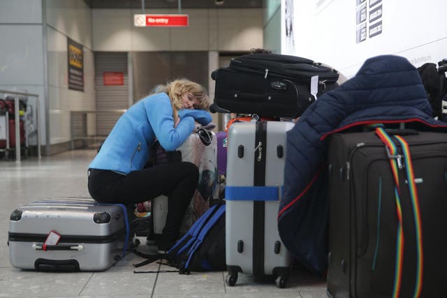 A traveller sleeps next to luggage at Heathrow Airport Terminal 5 after British Airways flights where cancelled after an IT systems failure