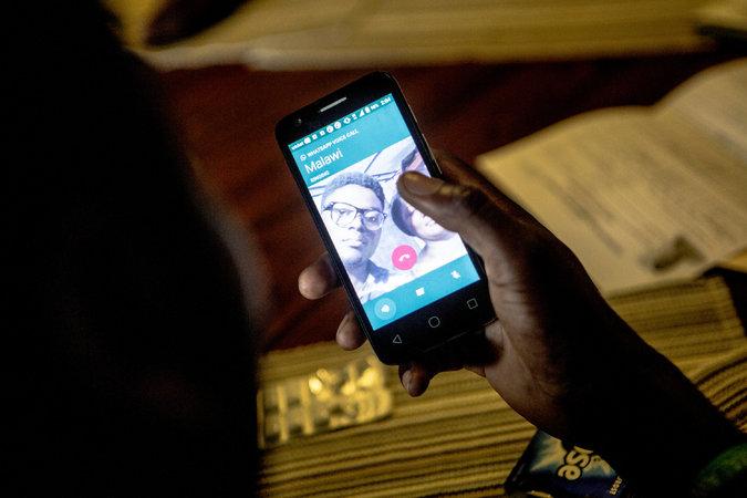 Jackson Mwenda makes a call to Mr Feruzi, his cousin back in Malawi. He will probably not be able to join the rest of his family for at least four months