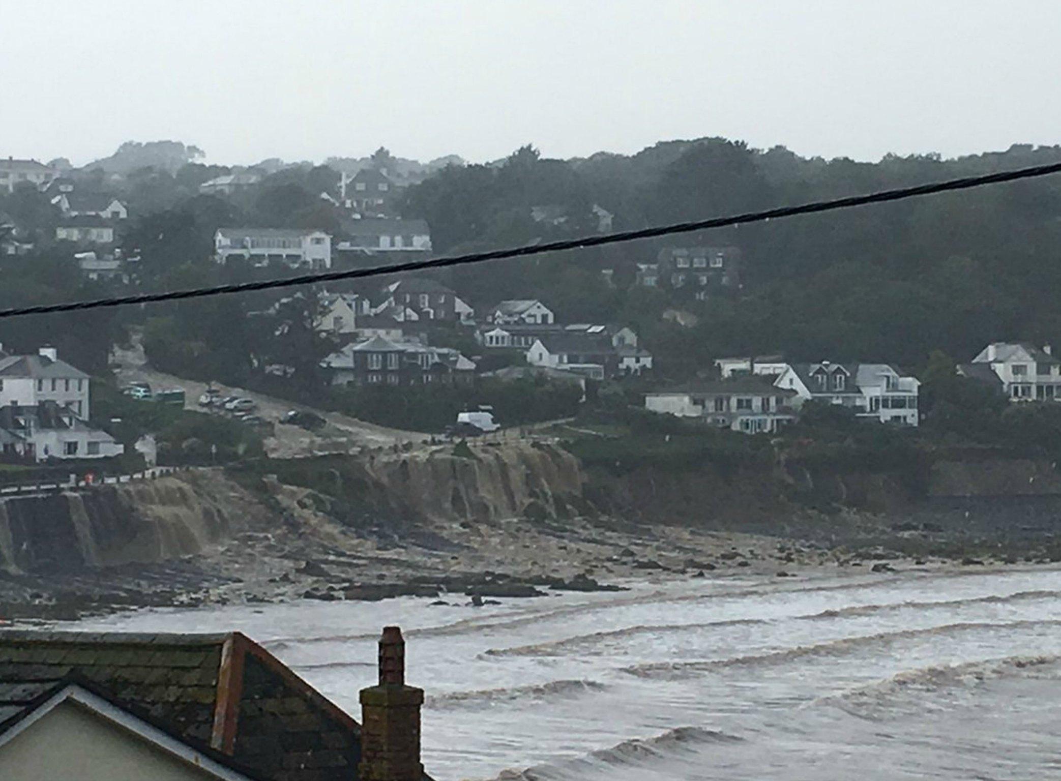 Flood waters pour over the sea wall in Coverack, Cornwall