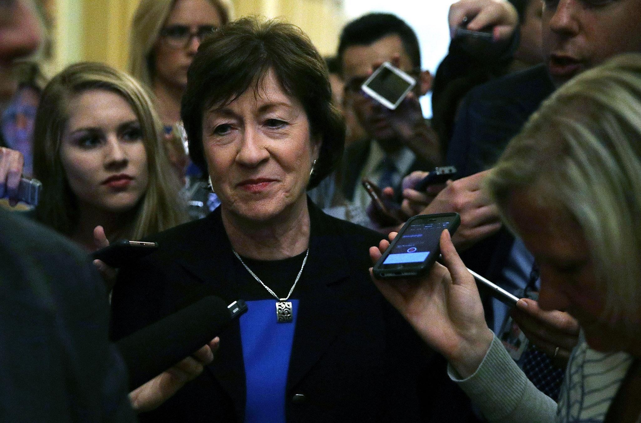Republican Senator Susan Collins is surrounded by members of the media
