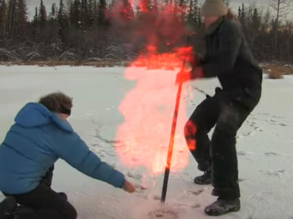Professor Katey Walker Anthony, of Alaska University, sets fire to methane released by hitting the frozen ground with a stick