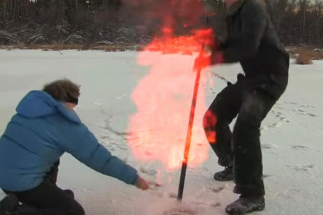 Professor Katey Walker Anthony, of Alaska University, sets fire to methane released by hitting the frozen ground with a stick