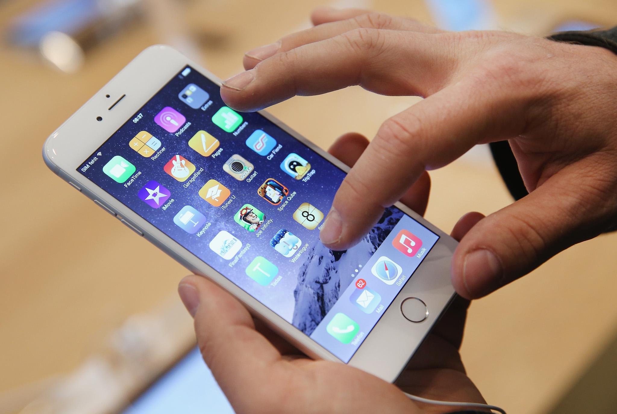 A shopper tries out the new Apple iPhone 6 at the Apple Store on the first day of sales of the new phone in Germany on September 19, 2014 in Berlin, Germany