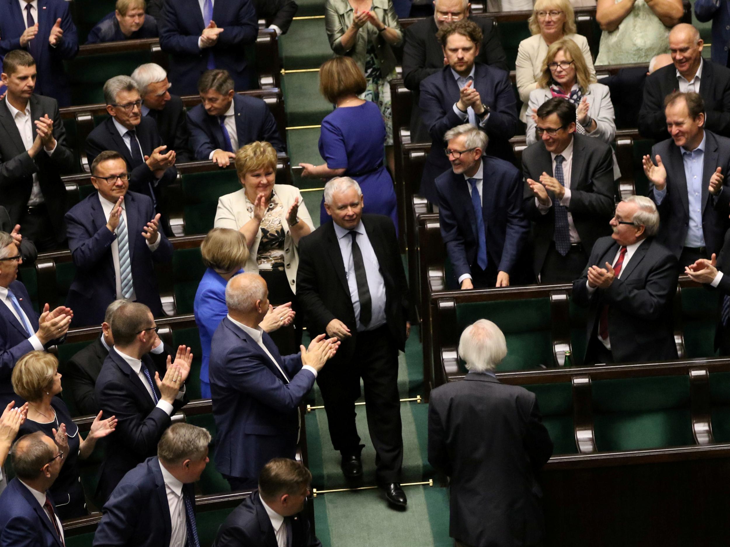 Law and Justice (PiS) party leader Jaroslaw Kaczynski enters parliament as his party members applaud