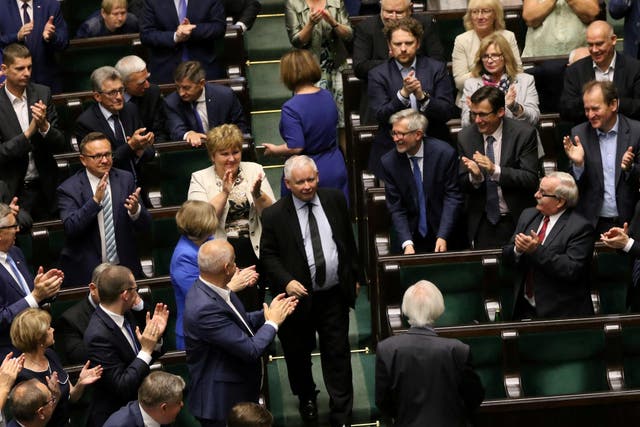 Law and Justice (PiS) party leader Jaroslaw Kaczynski enters parliament as his party members applaud