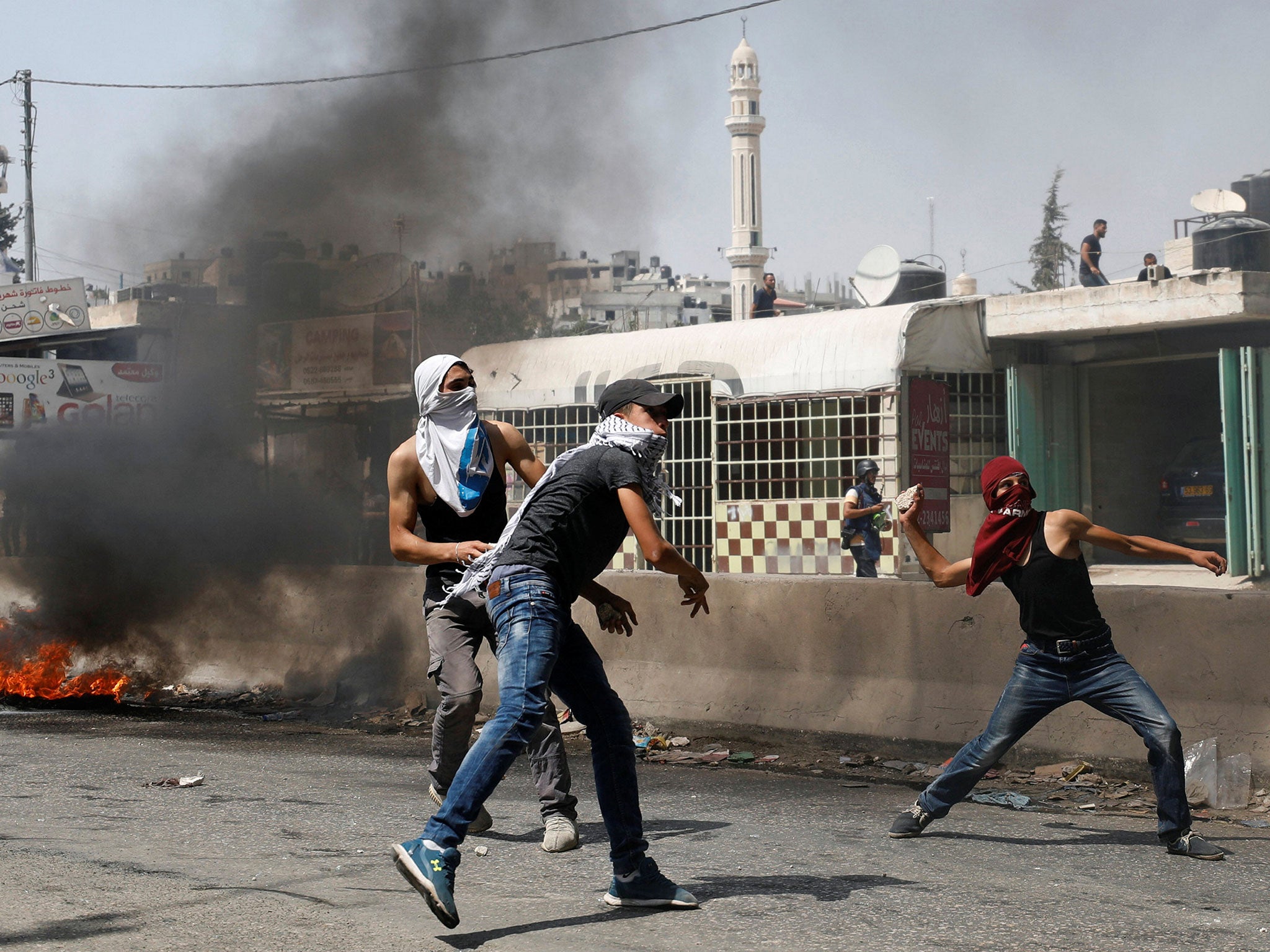 Palestinian protesters hurl stones towards Israeli troops during the violence