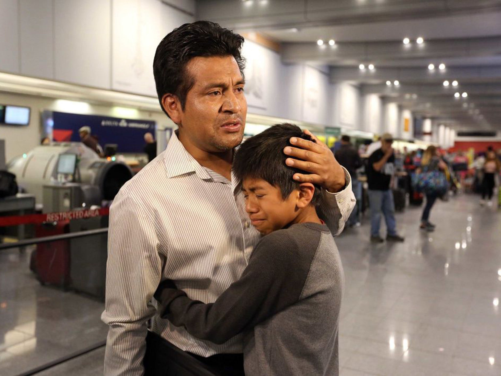 Mr Lara Lopez comforts his son before being deported to Mexico after 16 years in the US