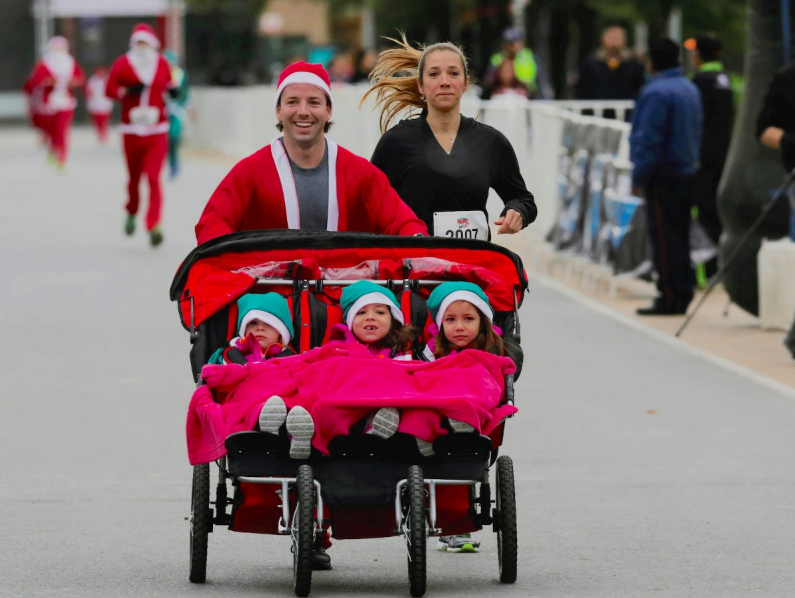 A man dressed as Santa Claus runs with his children in Run Santa Run event at Fundidora park in Monterrey, Mexico December 18, 2016