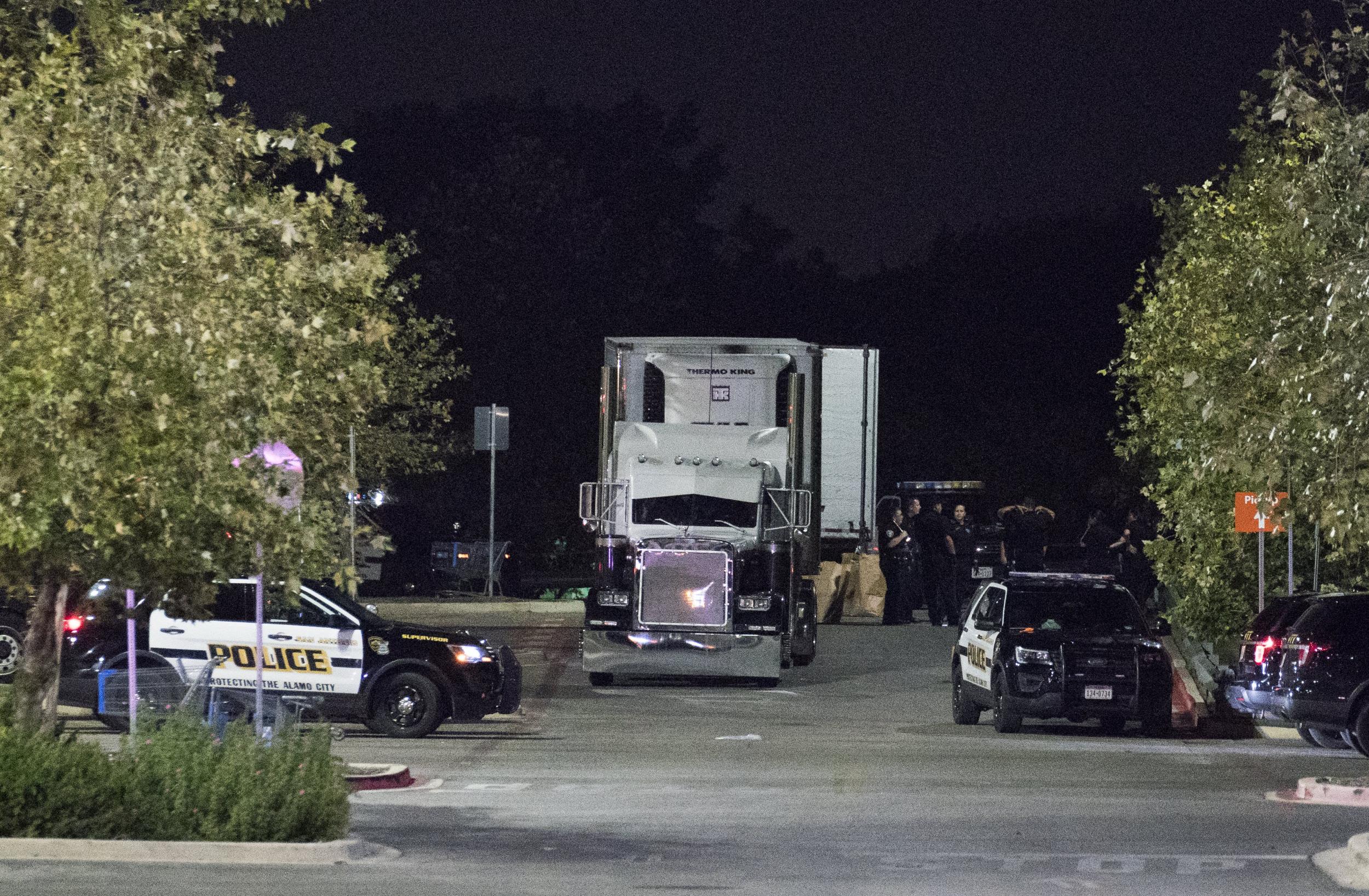 Officials investigate a truck that was found to contain 38 suspected illegal immigrants and eight dead bodies in San Antonio