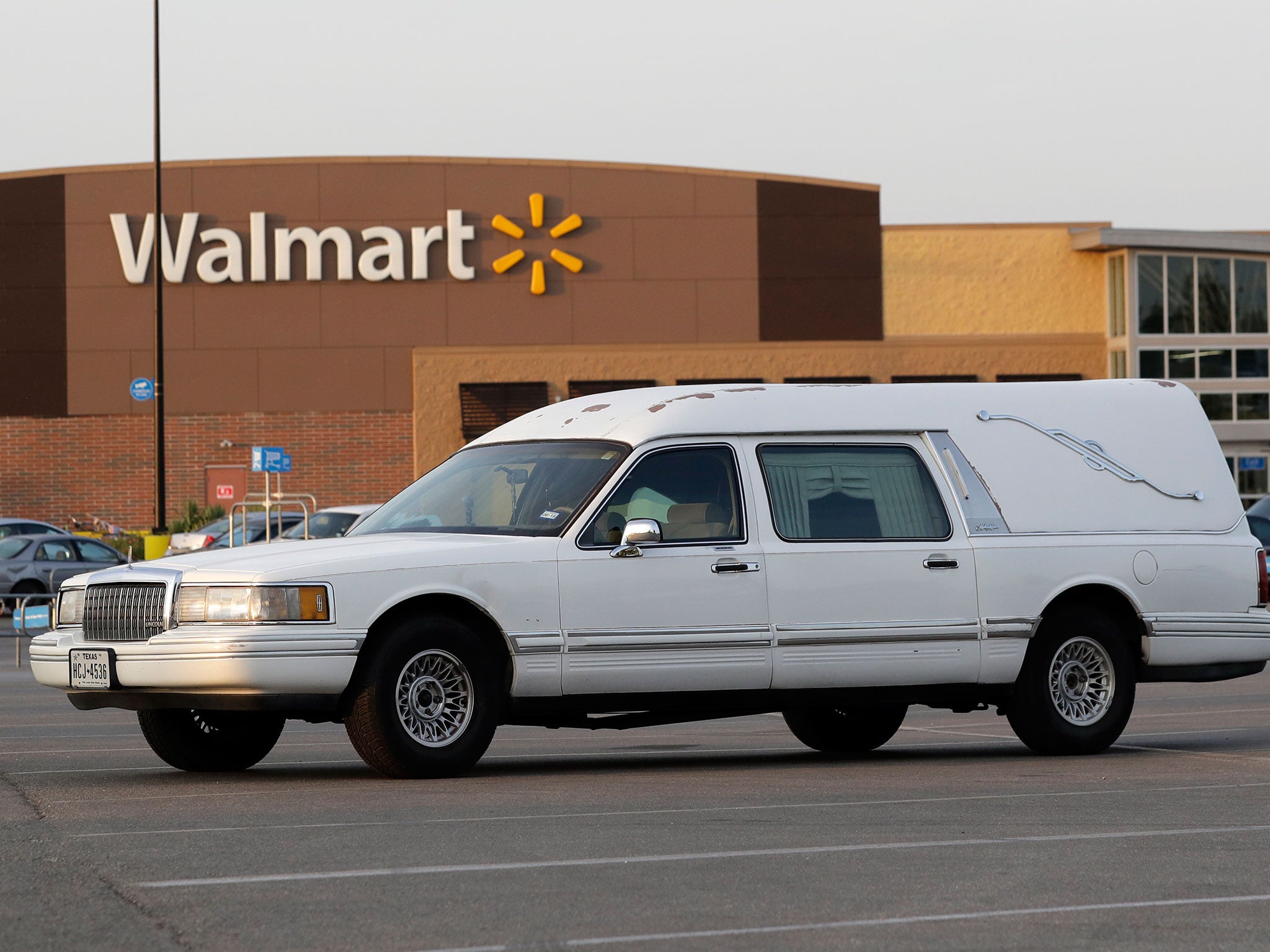 A hearse sits in the car park of a Walmart supermarket in San Antonio, where eight people were found dead in a tractor-trailer loaded with at least 30 others on 23 July