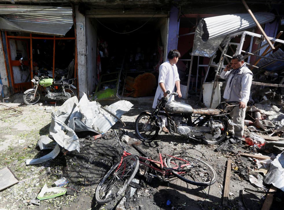 Shopkeepers survey the damage done to their businesses after a suicide attack in Kabul, Afghanistan on 24 July 2017