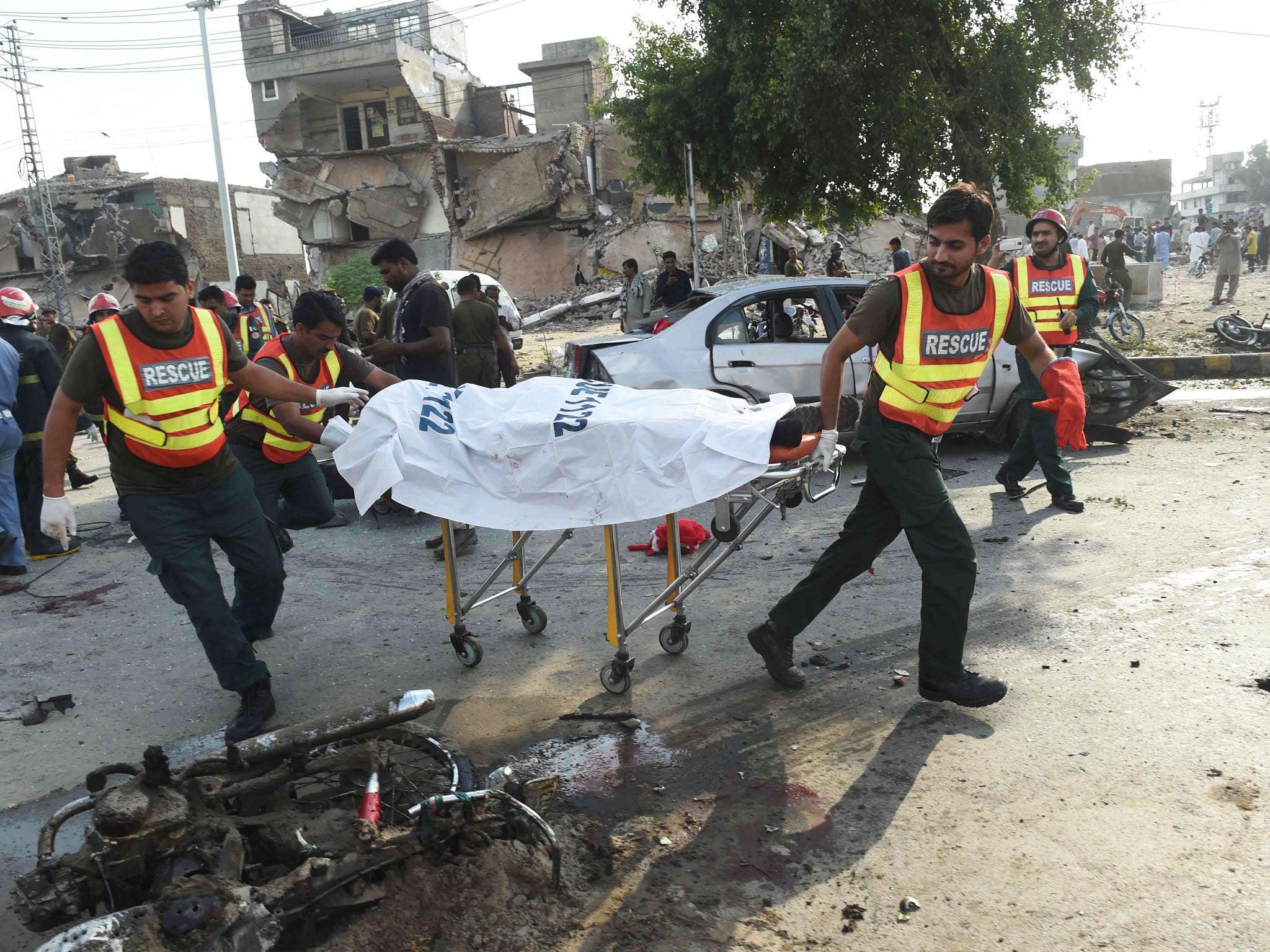 Pakistani rescue workers move the body of a victim at the site of the explosion