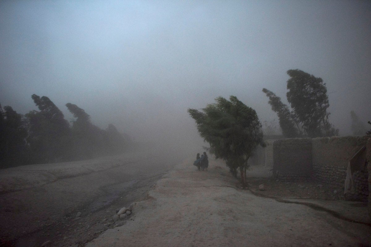 Children make their way home through a violent storm in Afghanistan’s Nangahar Province