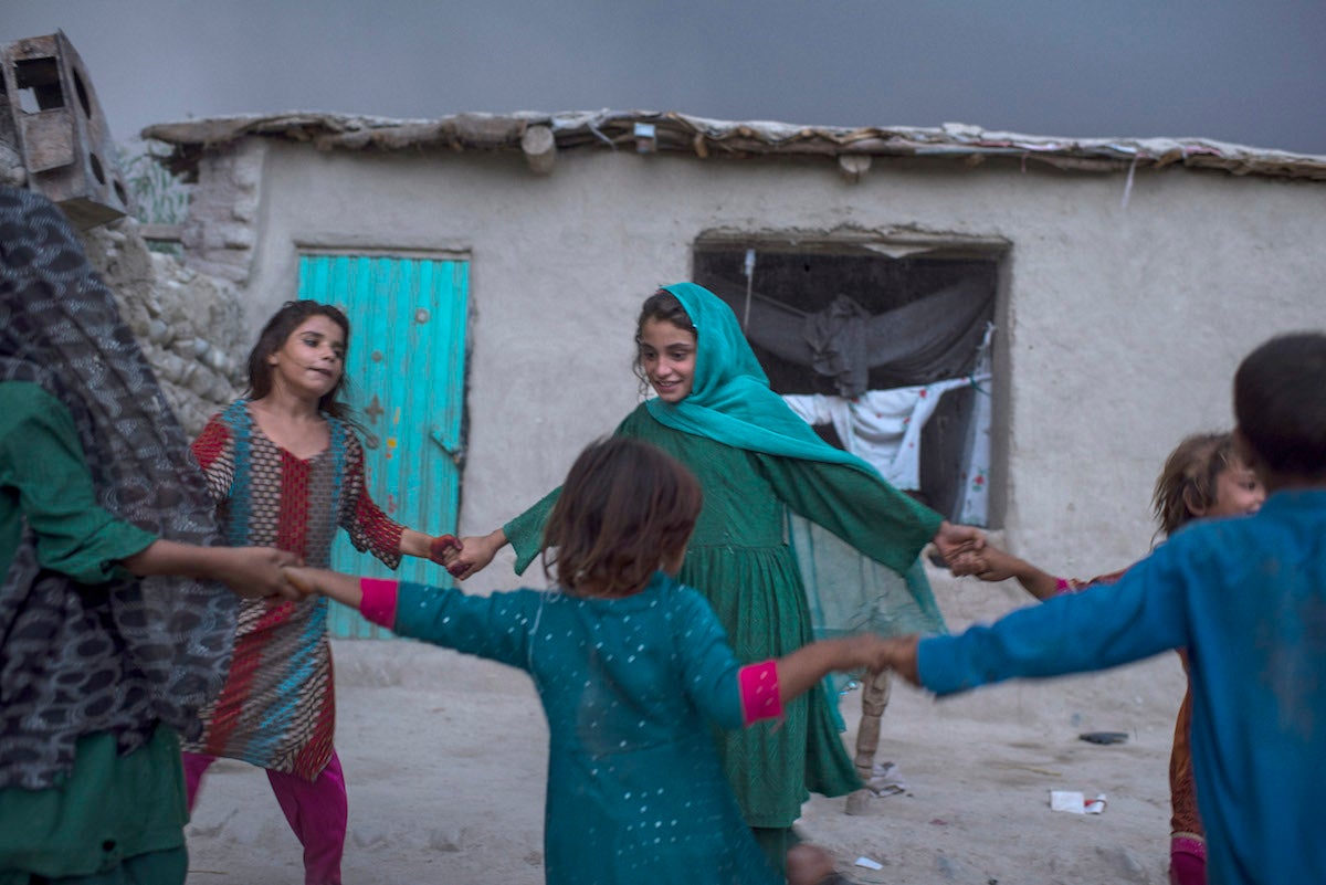 Shaguftar’s children play with neighbours – also from families displaced by conflict – in the yard of their simple house in Surkh Rod district of Nangahar Province