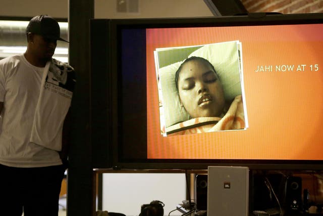 A recent photo of Jahi McMath is shown on a video screen next to her uncle Timothy Whisenton at a news conference in San Francisco