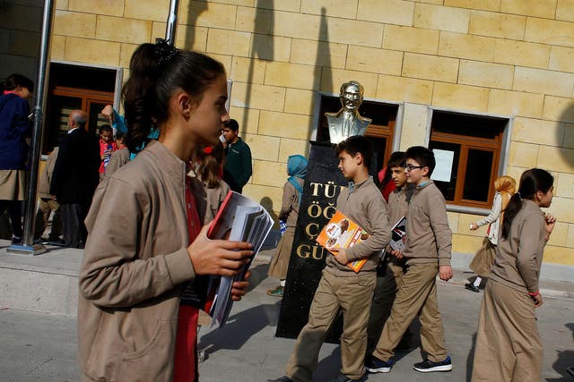 Students at one of Turkey's growing number of 'Imam Hatip' religious schools walk past a statue of Mustafa Kemal Ataturk, founder of secular Turkey, in Ankara