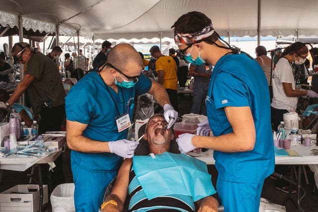 Matt Gaynier, left, and Rick Sykes, both dental students in Richmond, made the six-hour journey to Wise to offer free care to patients like Thomas Wyatt