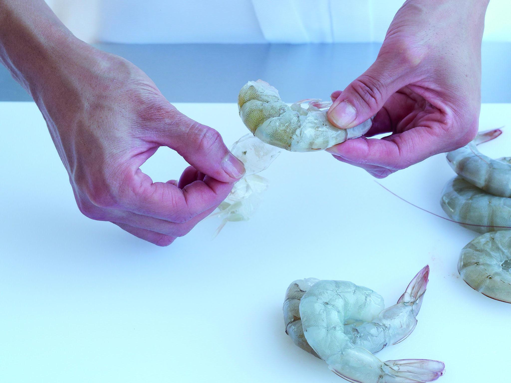 2. Peel the tails. The tail shells are soft and hinged and can be removed piece by piece or in several pieces at a time. Start to peel away the shells from the underbelly of the prawn. The tail tip can be kept on or carefully removed