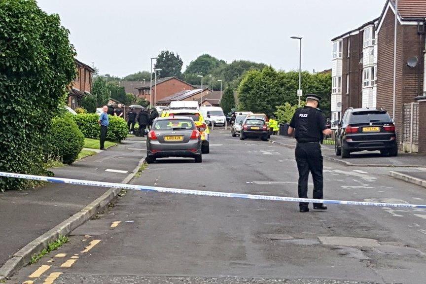Police have cordoned off a street in Oldham after an armed man took a woman hostage