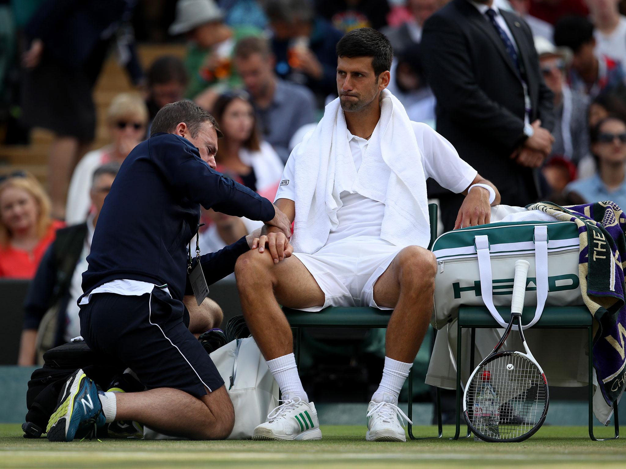 Novak Djokovic receives treatment during his quarter-final clash against Thomas Berdych at Wimbledon