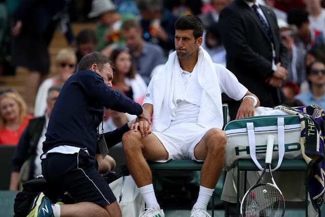 Novak Djokovic receives treatment during his quarter-final clash against Thomas Berdych at Wimbledon