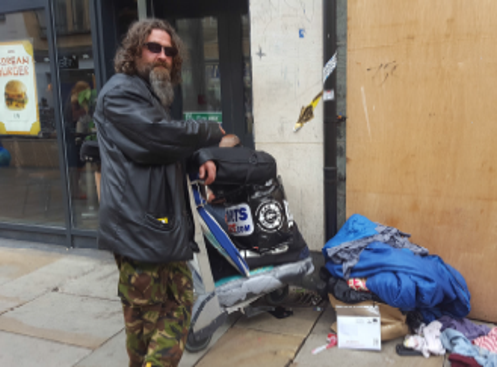 A homeless man in Oxford points to council notice placed on his possessions