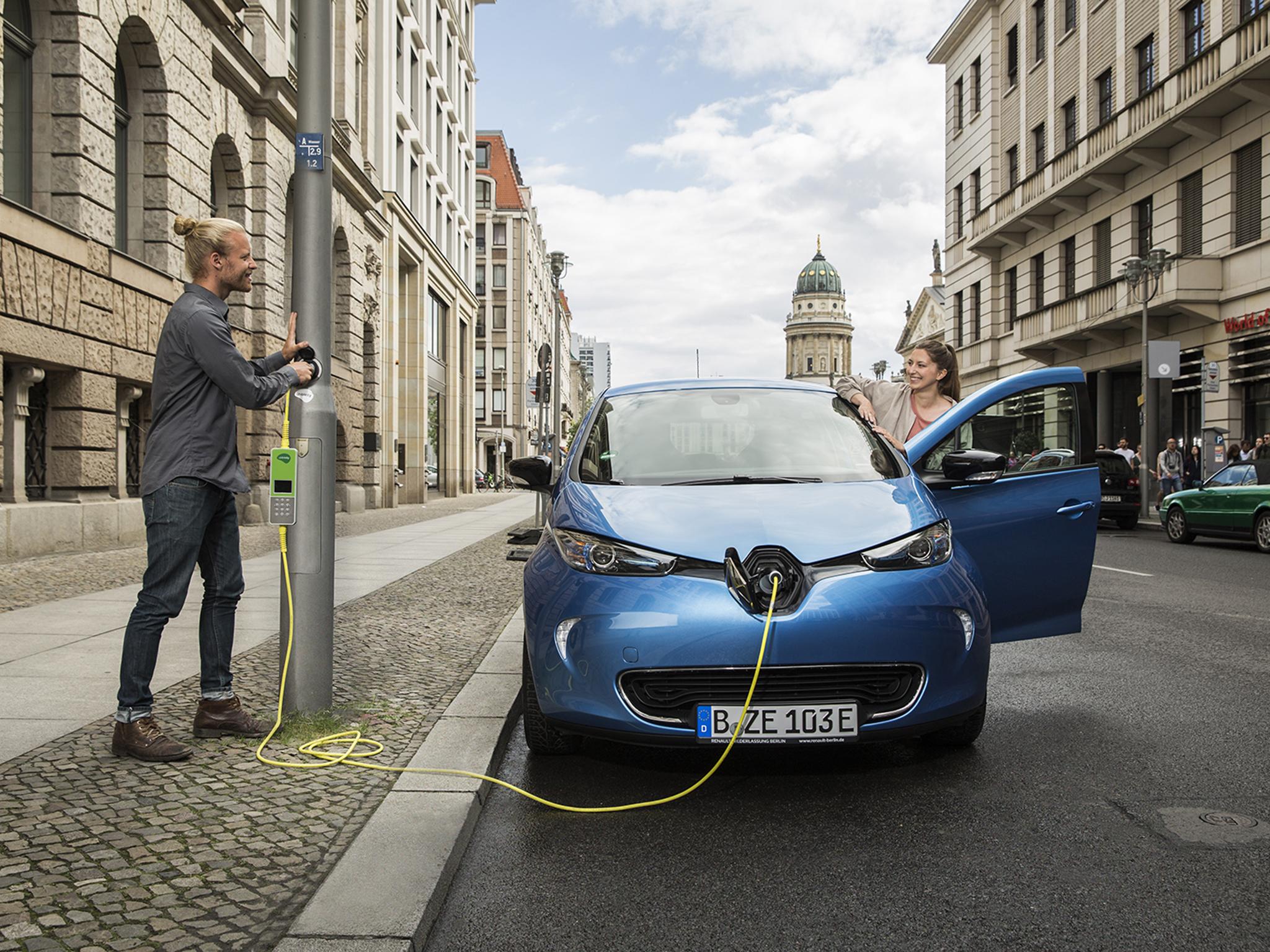 A man uses one of the new electric charging points in a London lamppost