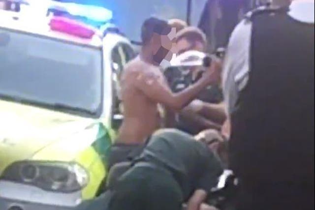Paramedics were filmed dousing one man with liquid after the attack