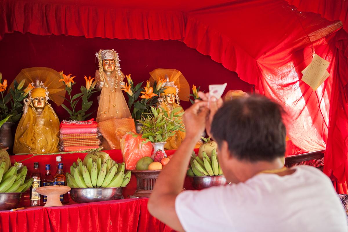 Nat-kadaw Mg Mg Kyi adds a cash offering to his shrine (Gemma Taylor)