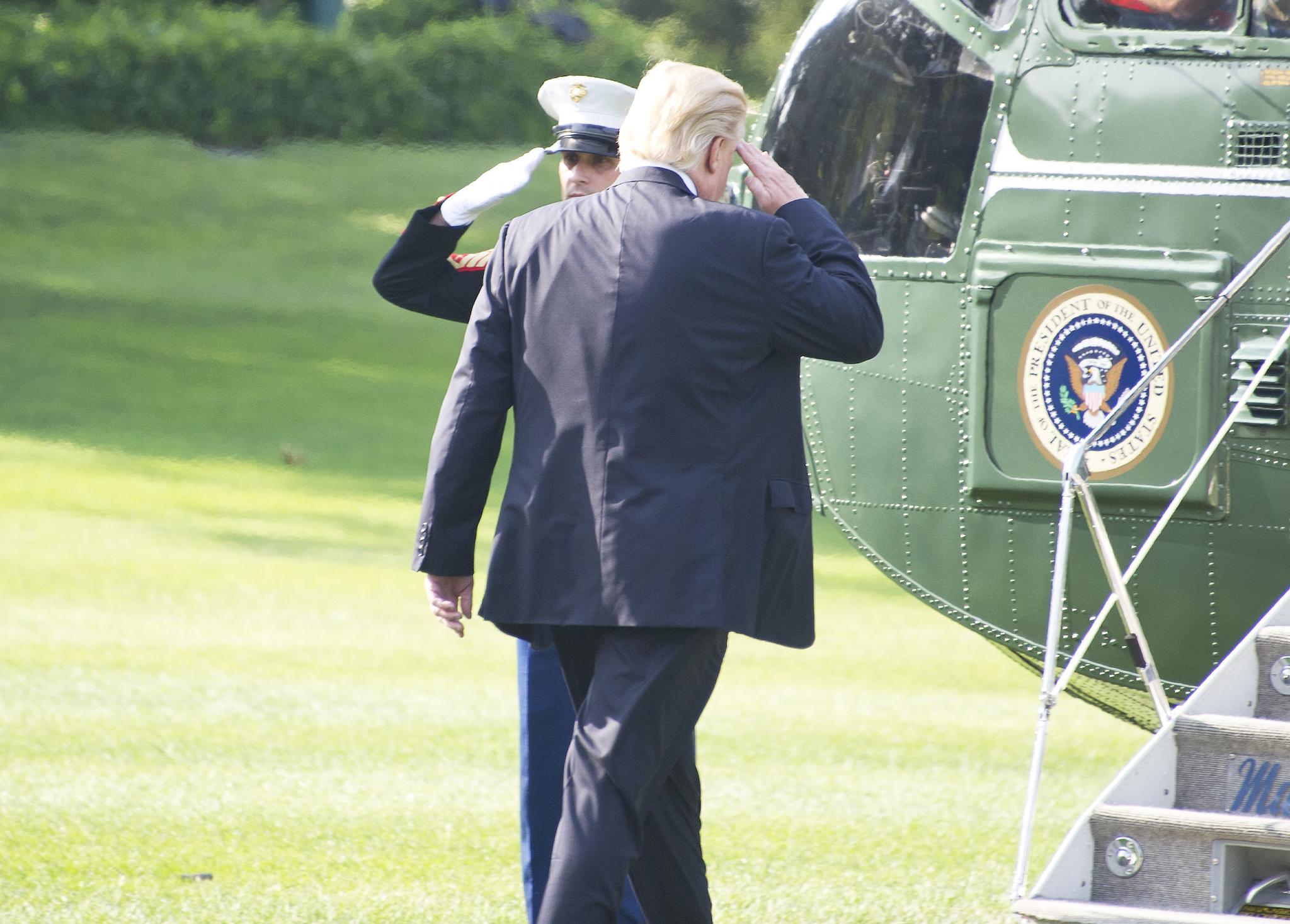 US President Donald Trump salutes the Marine Guard as he departs the White House