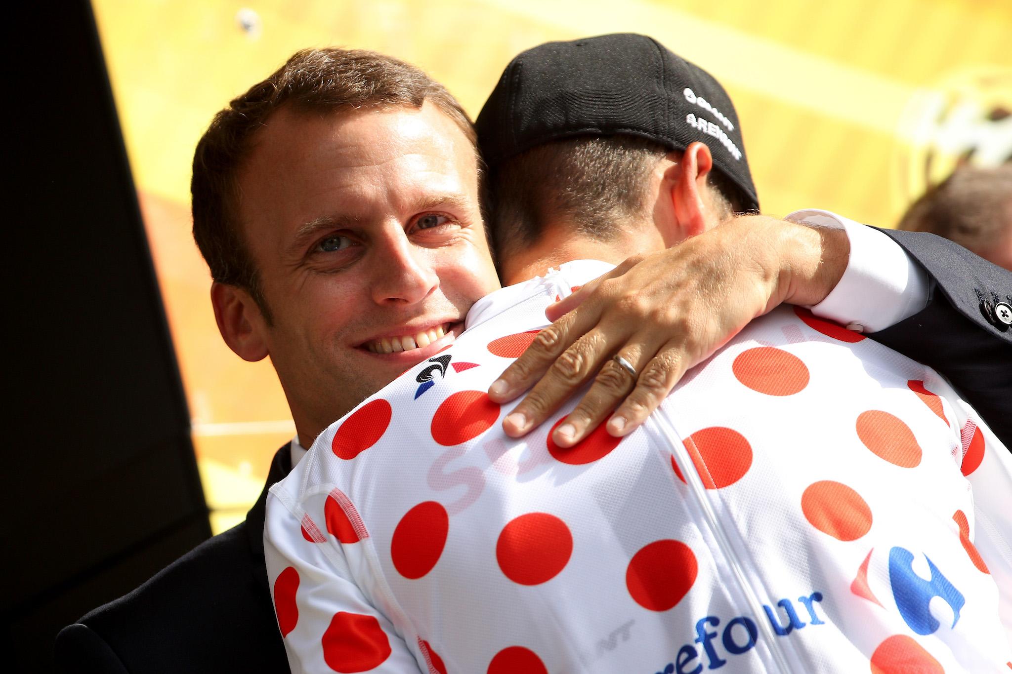 Warren Barguil of France riding for Team Sunweb stands on the podium in the king of the mountain jersey and talks with French President Emmanuel Macron