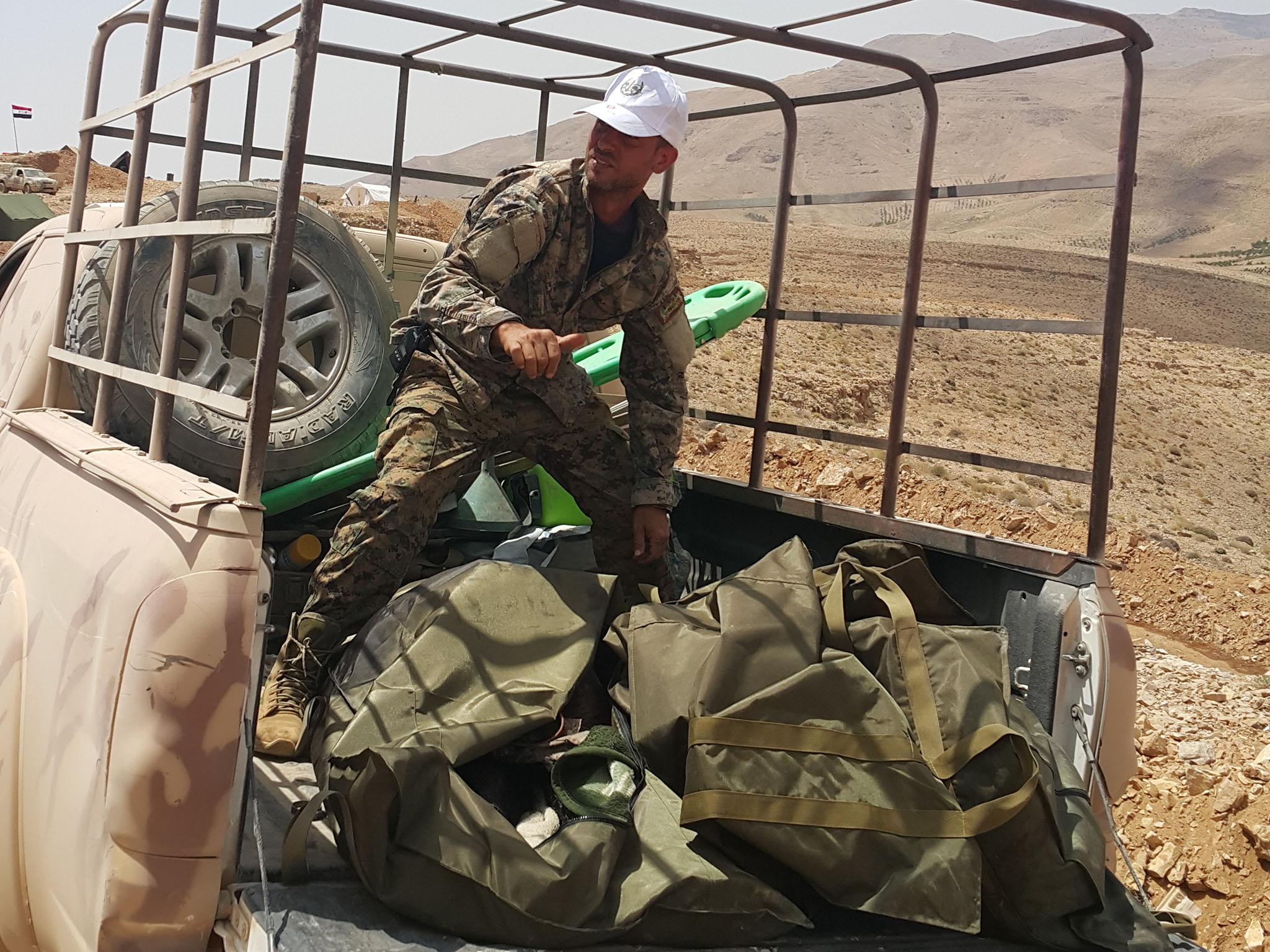 A Syrian officer identifies three dead Isis fighters in body bags at the captured Qalamoun fortress