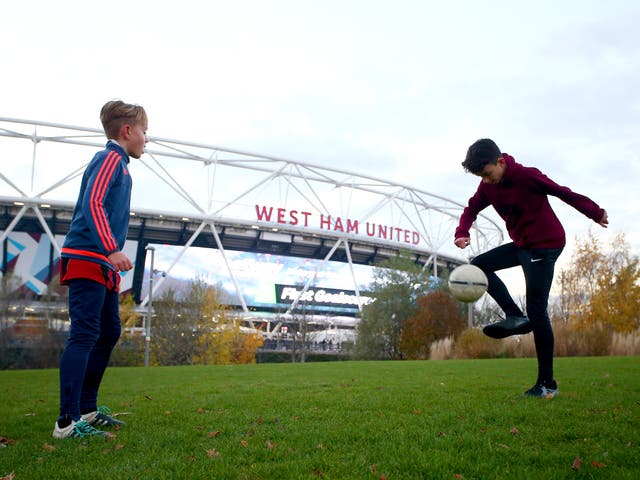 Two children play in the shadow of the Olympic Stadium, now West Ham United's home ground