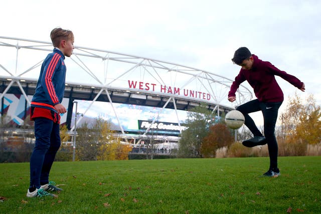 Two children play in the shadow of the Olympic Stadium, now West Ham United's home ground