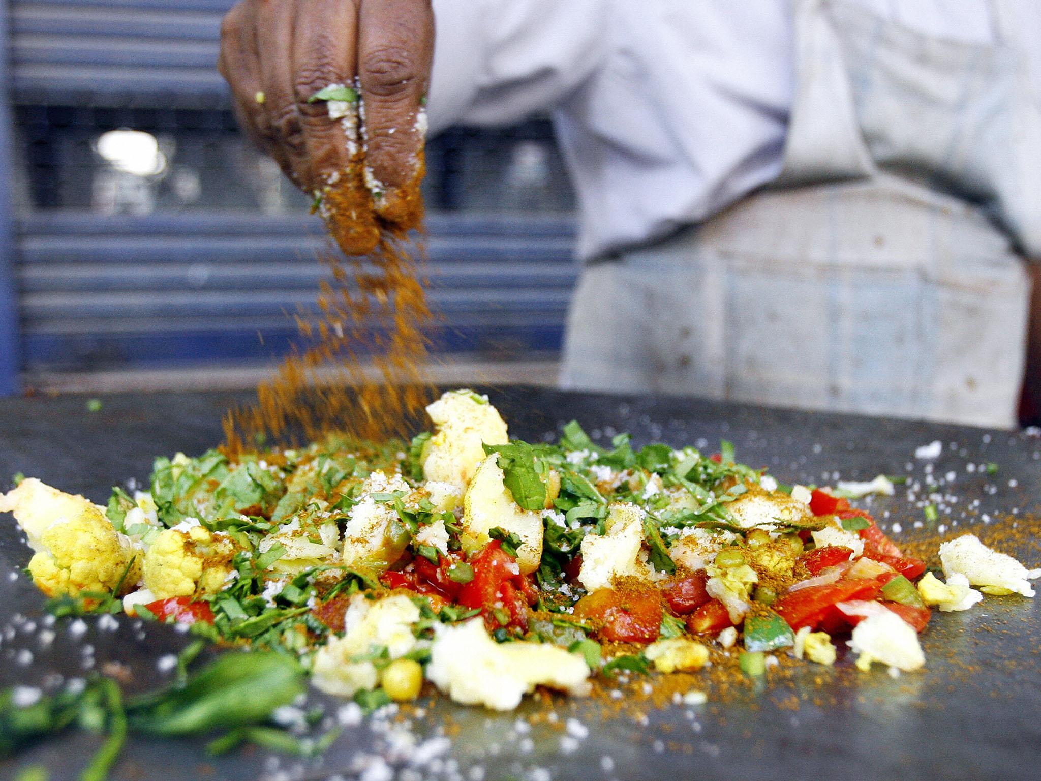 A food vendor prepares a dish at his roadside stall in Mumbai