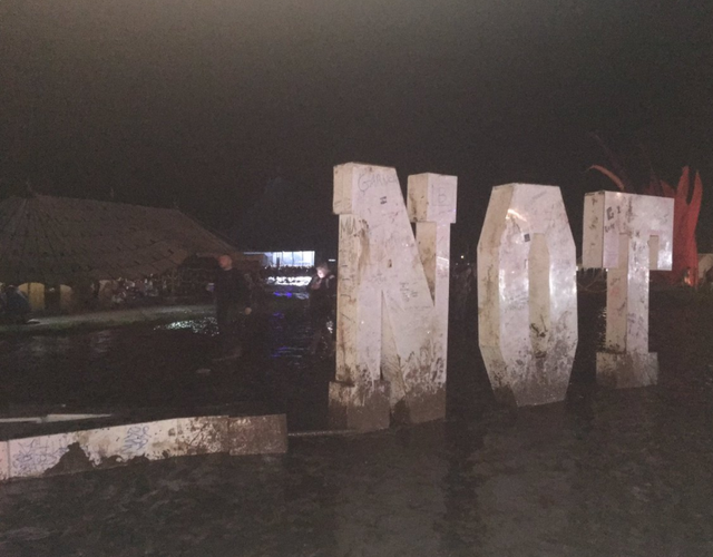 A sign sits in mud at the festival after organisers asked festival-goers to leave for their own safety