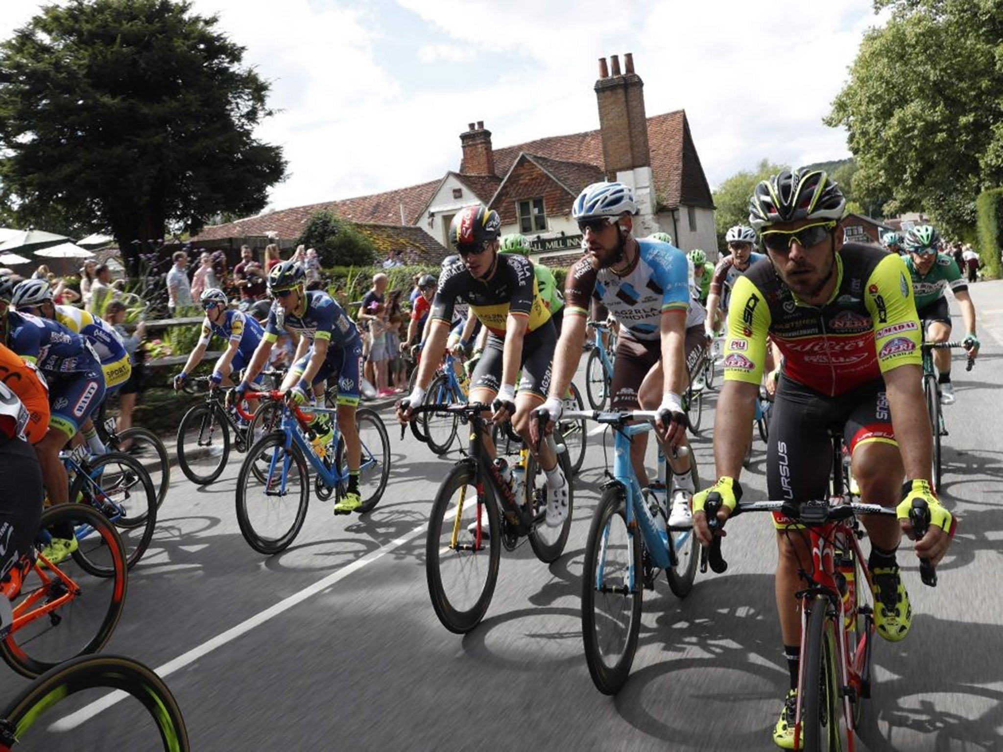 RideLondon riders cycling through a Surrey village on the route