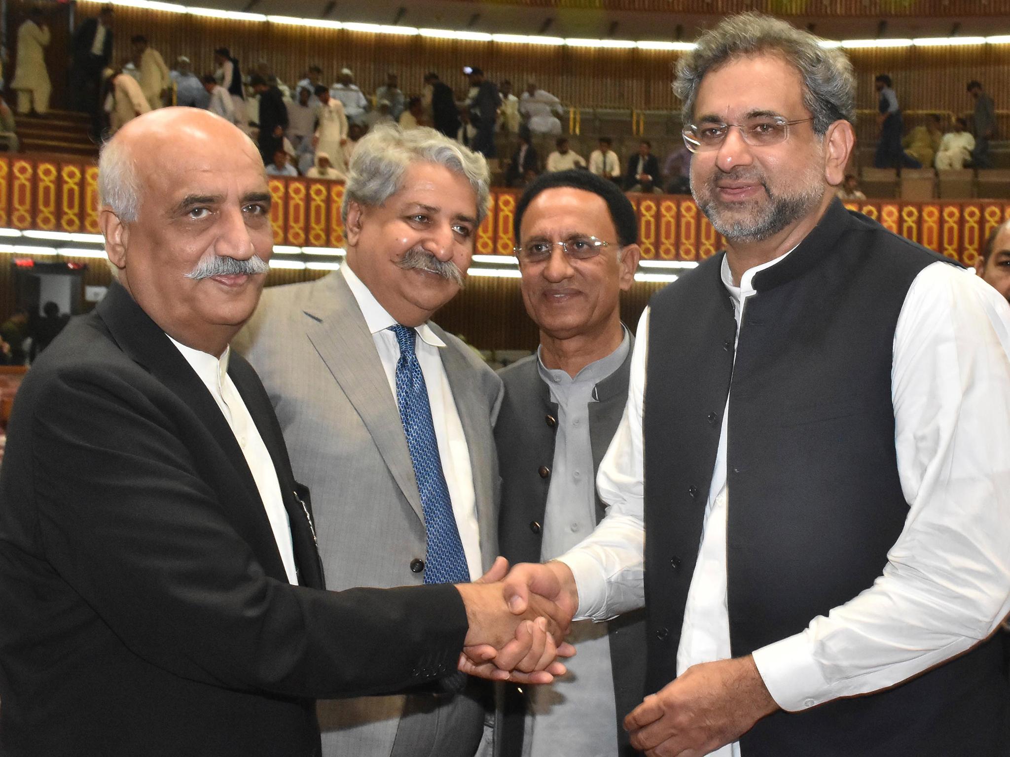 Newly-elected prime minister of Pakistan Shahid Khaqan Abbasi, right, is greeted by the Opposition leader Khursheed Shah, left