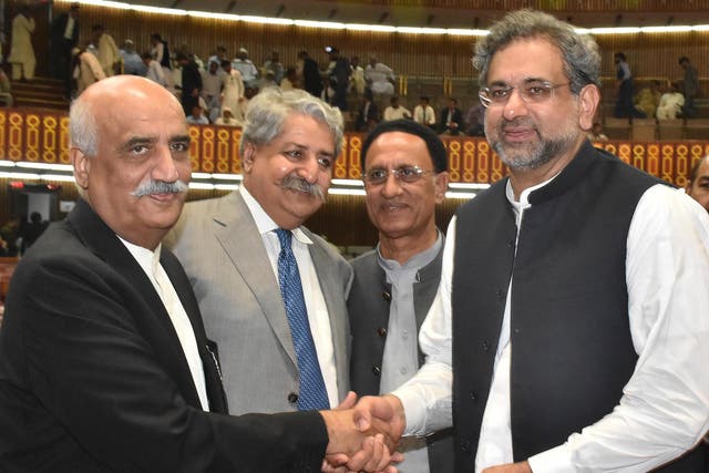 Newly-elected prime minister of Pakistan Shahid Khaqan Abbasi, right, is greeted by the Opposition leader Khursheed Shah, left