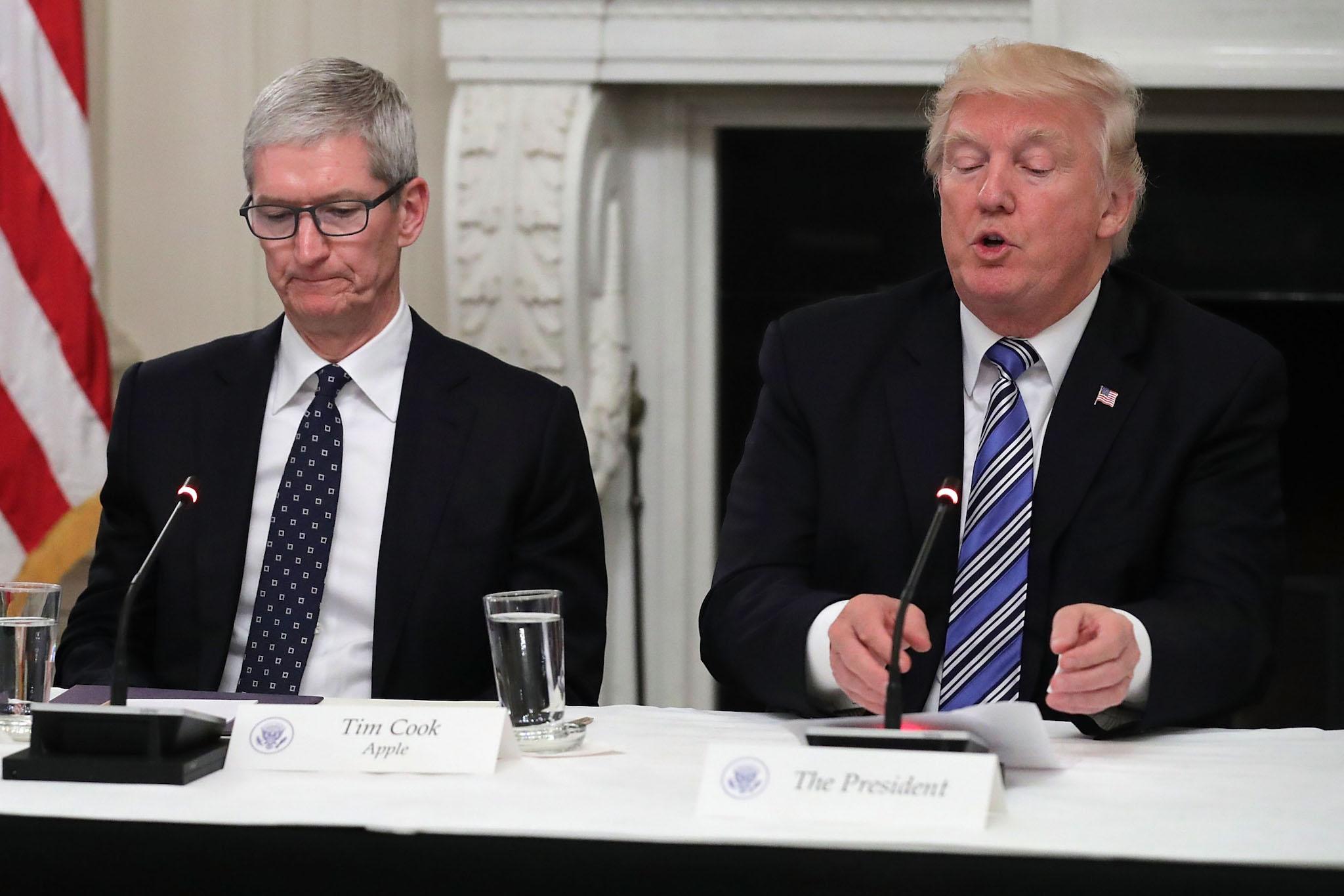Apple CEO Tim Cook listens to US President Donald Trump deliver opening remarks during a meeting of the American Technology Council