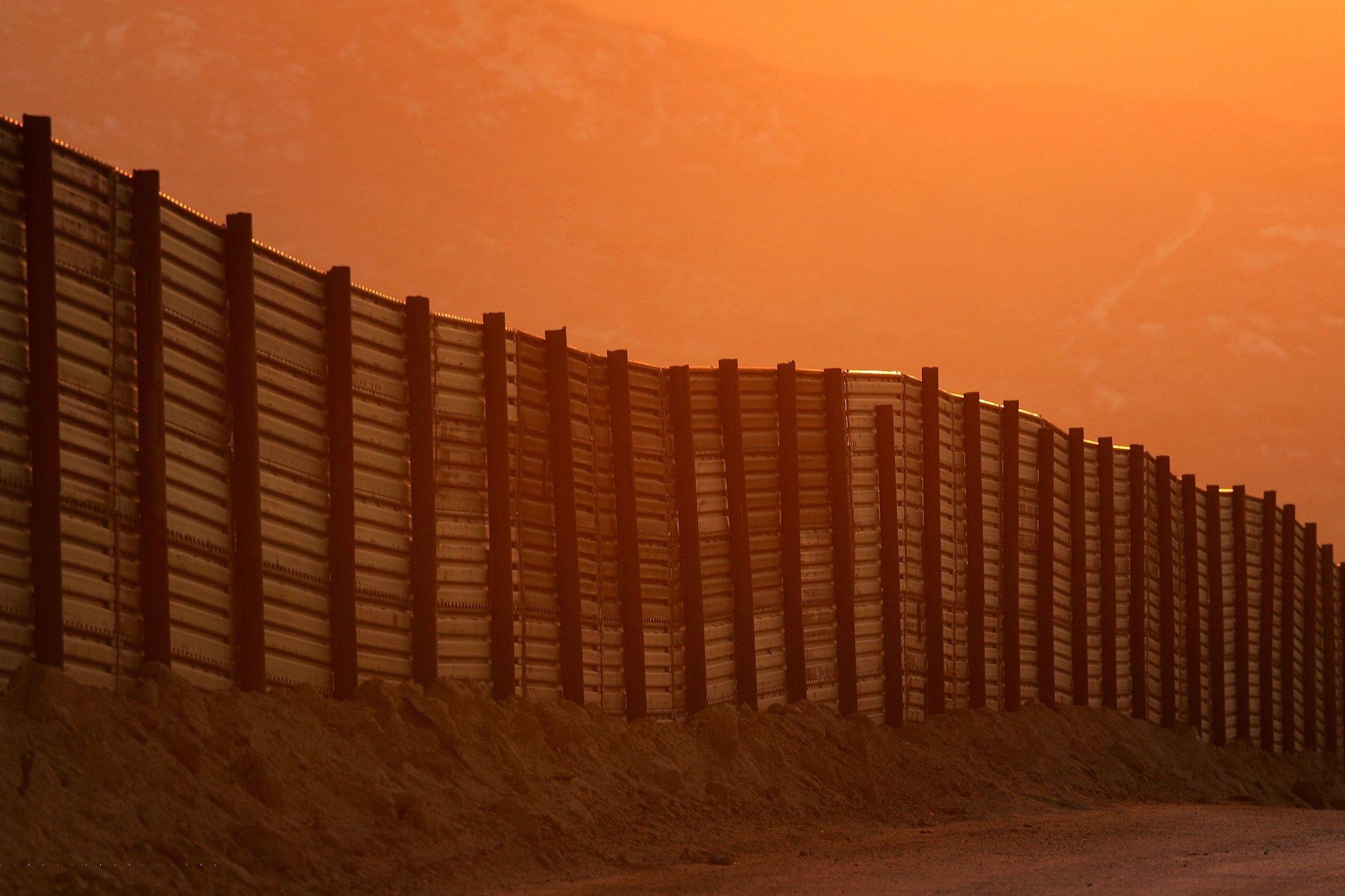 Dusk falls over a section of the US-Mexico border fence