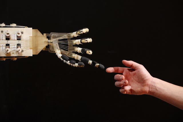 Robotics student Gildo Andreoni interacts with a Dexmart robotic hand built at the University of Bologna in the Robotville exhibition at the Science Museum on November 29, 2011 in London, England