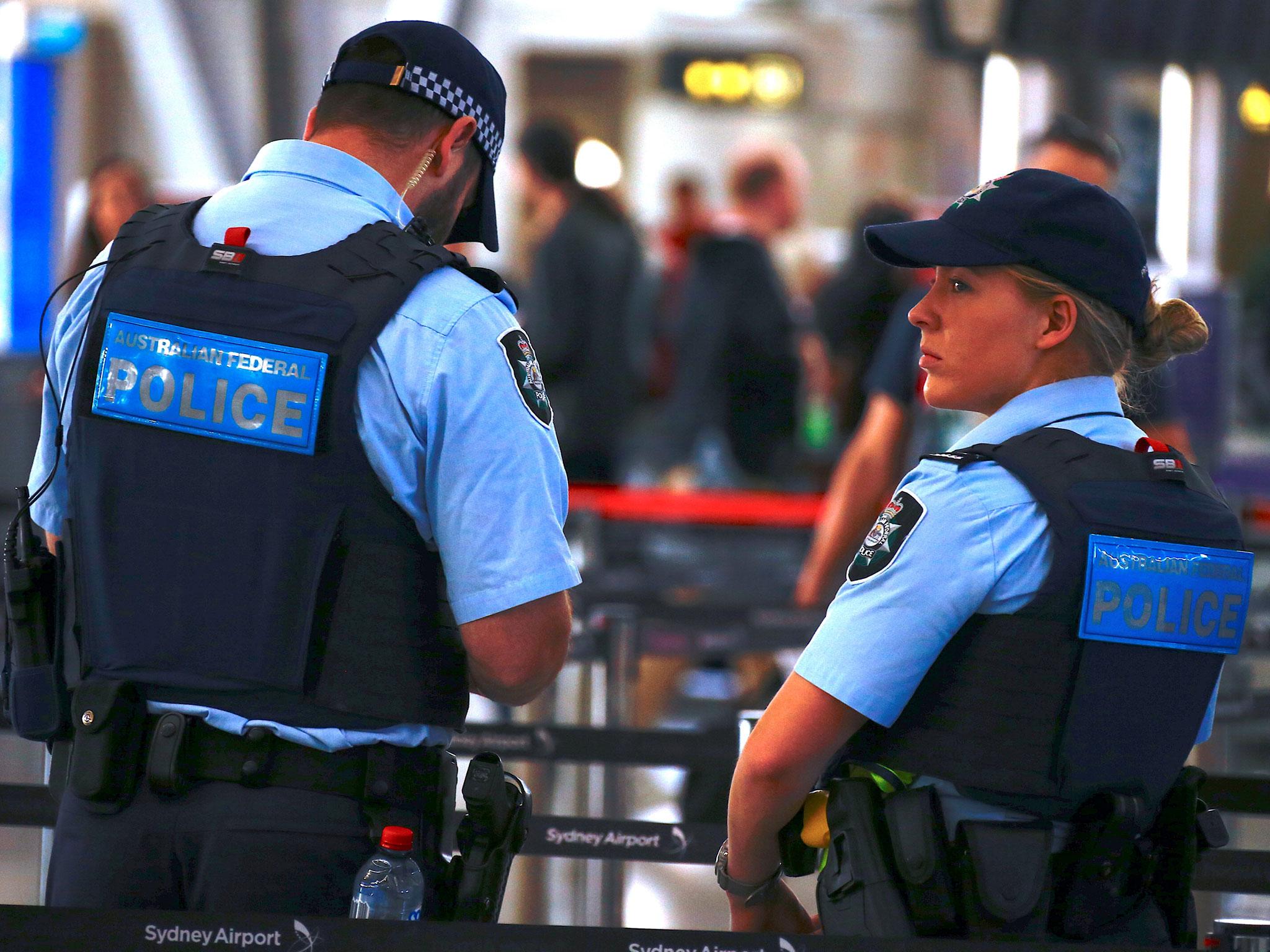 Australian Federal Police officers stand near the check-in counters at the Sydney Airport Domestic terminal in Australia