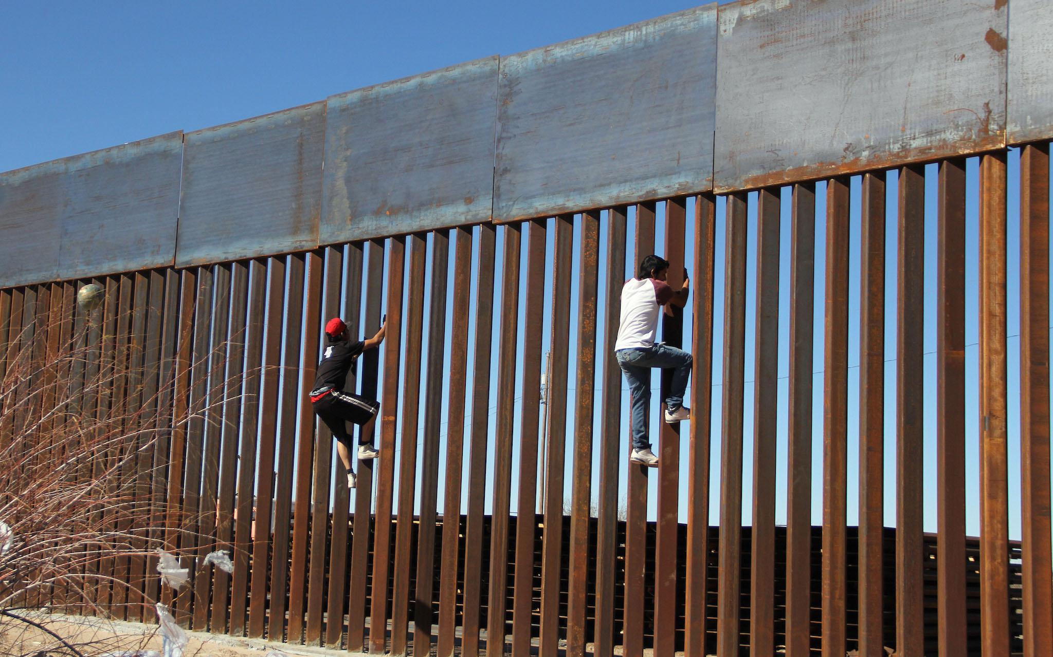 Boys play around, climbing the border division between Mexico and the US in Ciudad Juarez