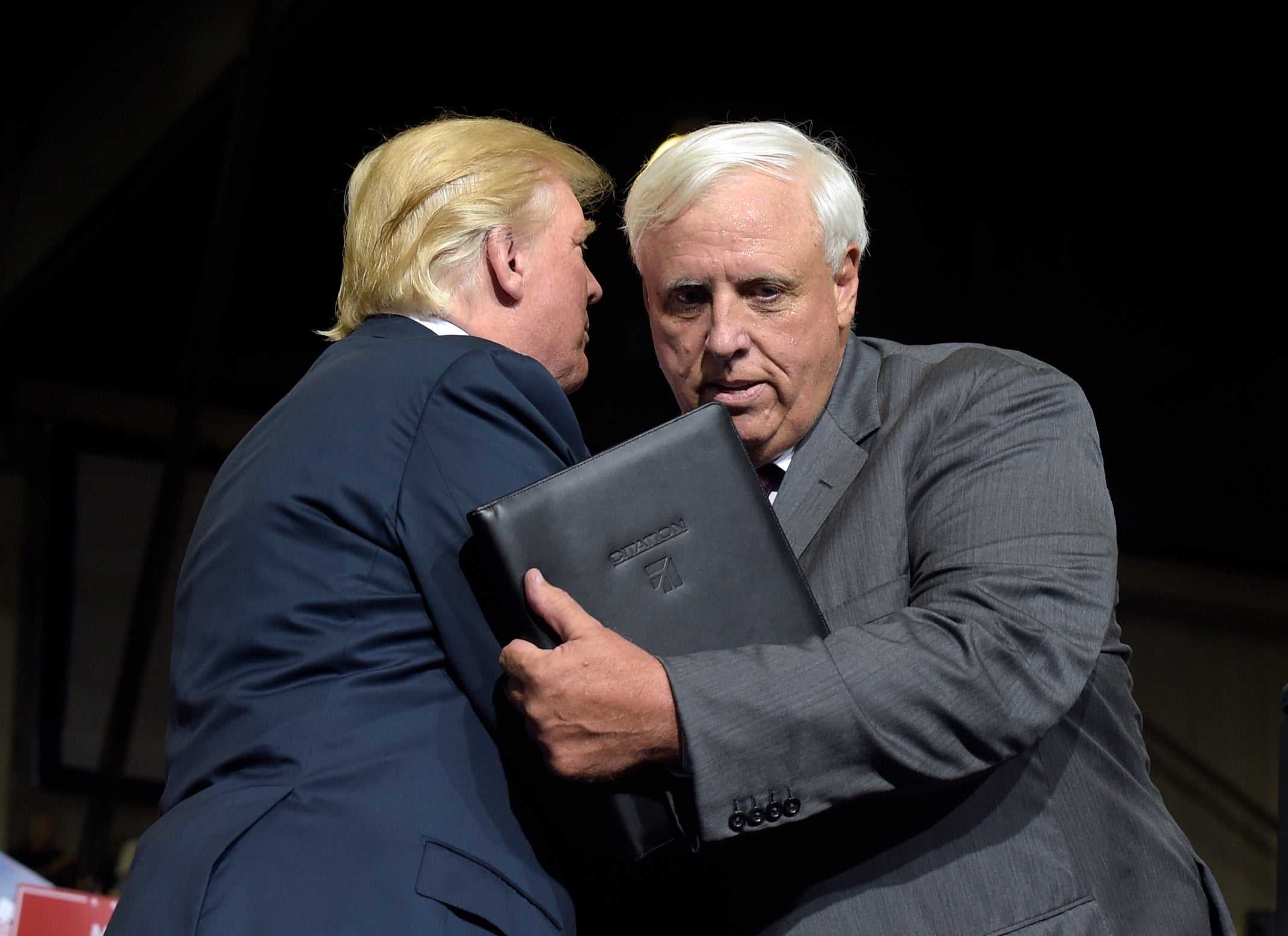 President Donald Trump embraces West Virginia Gov. Jim Justice after Justice announced during a rally that he was switching his registration to Republican.