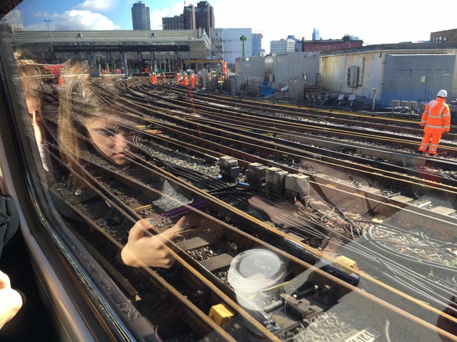 All change: A commuter reflected in a train window on the approach to Waterloo Station in London